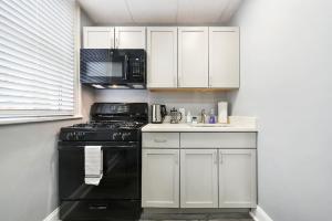 uma cozinha com um fogão preto e armários brancos em Beauty Sleep on Bellevue 