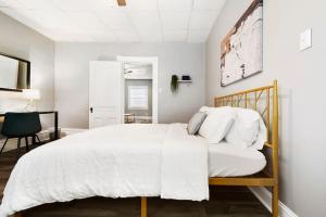 um quarto branco com uma cama e uma cadeira em Beauty Sleep on Bellevue 