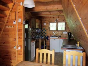 a kitchen in a log cabin with a refrigerator at Jeżówka in Sasino