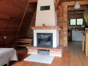 a living room with a fireplace in a cabin at Jeżówka in Sasino +6 photos
