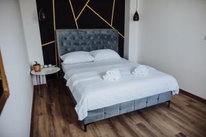 Schlafzimmer mit einem großen Bett mit blauem Kopfteil in der Unterkunft Modern Apartment 3 in Brčko