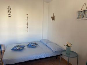 a bed in a room with two pillows on it at Appartamento Il Corallo Blu in Lampedusa