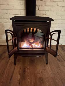 una estufa negra con chimenea en una habitación en Lovely oceanside 1-bdrm suite Fireplace HotTub, en Crofton