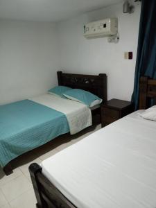 a bedroom with two beds and a heater on the wall at Hotel Rosandy Galaxy in Cartagena de Indias