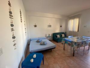 a living room with a bed and a table at Appartamento Il Corallo Blu in Lampedusa