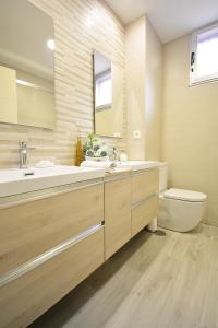 a bathroom with a sink and a toilet and a mirror at Apartamento en pleno centro de Portonovo, Sanxenxo in Sanxenxo