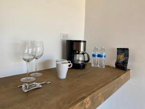 a counter with two wine glasses and a coffee maker at Palta 60 Valle de Guadalupe in Valle de Guadalupe