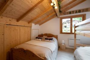 a bedroom with a bed in a wooden house at L’Ecrin Blanc – Cocon familial avec jacuzzi et salle de jeux in Liézey