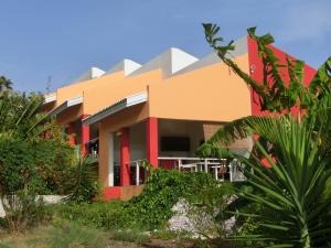 een rood en oranje gebouw met planten ervoor bij Don Genaro Apartments in Barber