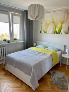 sypialnia z łóżkiem i obrazem kwiatów w obiekcie Apartament Redłowo w mieście Gdynia