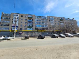 a parking lot with cars parked in front of a building at Sapar APARTMENTS 1 in Aktobe