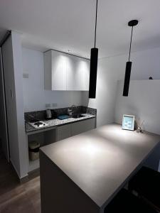 a kitchen with white cabinets and a counter top at Rentarte in Pilar +56 photos