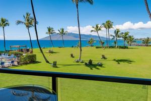 Elle offre une vue sur un parc planté de palmiers et l'océan. dans l'établissement Enjoy Your Oceanside Dream at Kihei Surfside, à Wailea