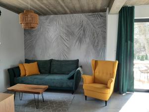 a living room with a green couch and a chair at Sosnowe Zacisze in Sasino