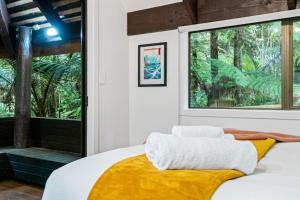 una camera da letto con un letto con una coperta gialla sopra di A 1BR slice of Titirangi Heaven - WiFi - Netflix ad Auckland