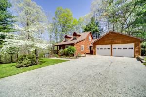 a house with a garage and a driveway at Peaceful Candler Cabin with Private Hot Tub! in Candler