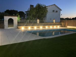 uma piscina com luzes num quintal à noite em Casa Rural Los Jarales em Casar de Cáceres