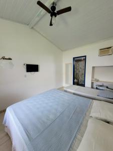 1 dormitorio con 1 cama y ventilador de techo en Pousada Luar, en Santa Cruz Cabrália