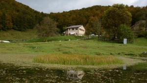 ein Haus auf einem Hügel neben einem Wasserkörper in der Unterkunft Agribed Quierta - Camere Matrimoniali 