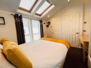 ein Schlafzimmer mit einem großen weißen Bett und einem Fenster in der Unterkunft 2 Bedroom Lodge TH35, Nodes Point, St Helens, Isle of Wight in Saint Helens