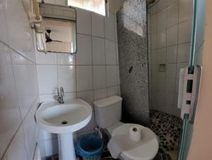 La petite salle de bains est pourvue d'un lavabo et de toilettes. dans l'établissement Pousada Luar, à Santa Cruz Cabrália