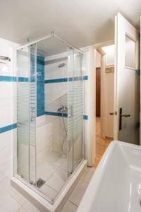 a glass shower in a bathroom with a tub at Blue Ark Gate to History in Athens