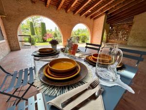 einen Tisch mit Tellern und Gläsern darüber in der Unterkunft SUNFLOWER APARTMENT in Peschiera del Garda