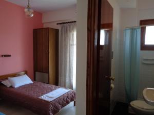 a bedroom with a bed and a bathroom with a shower at Skyline in Velonádes