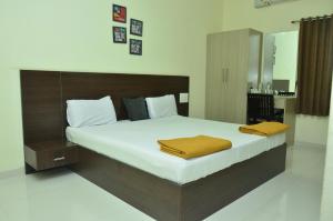 a bedroom with a large bed with a wooden headboard at THE SURRYA MAX RESIDENCY in Pollāchi