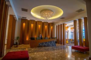 a lobby with a reception desk and a chandelier at Parwar Hotel in Duhok