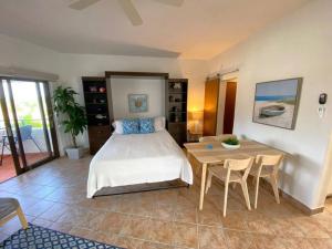 Schlafzimmer mit einem Bett und einem Tisch mit Stühlen in der Unterkunft KASA Rio Mar Villa for 2 in Rio Grande