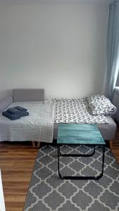 Bett in einem Zimmer mit einem Teppich und einem Bett mit einem Bettrahmen in der Unterkunft Apartament 41 in Częstochowa