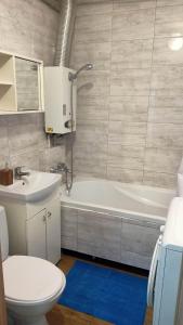 ein Badezimmer mit einer Badewanne, einem WC und einem Waschbecken in der Unterkunft Apartament 41 in Częstochowa