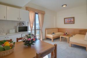 a kitchen and a living room with a table and a kitchen and a living room at Mare Hotel Apartments in Agios Nikolaos