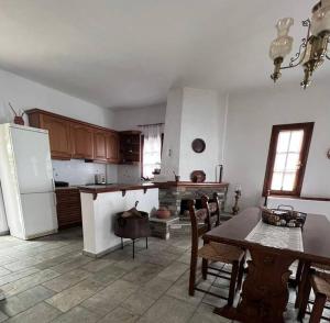 a kitchen with a table and a white refrigerator at Sea & Mountain Pelion in Mouresi