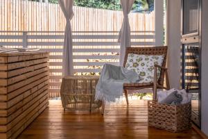eine Veranda mit einem Schaukelstuhl und einem Zaun in der Unterkunft Camping Resort Tina Vrsar in Vrsar