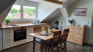 cocina con mesa de madera y sillas en Ferienwohnung Schulz en Dresden