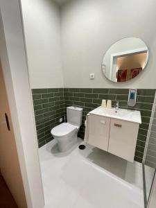 a bathroom with a white toilet and a mirror at Centro da Vila in Ponte de Lima