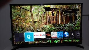 a television screen with a picture of a tree at Casa Recanto 2 in Campos do Jordão