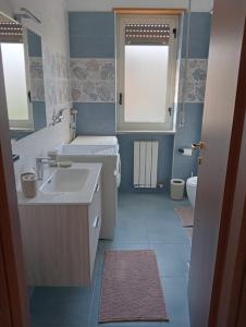 a blue bathroom with a sink and a toilet at casa LULU due minuti dal mare in Ardore Marina +12 photos