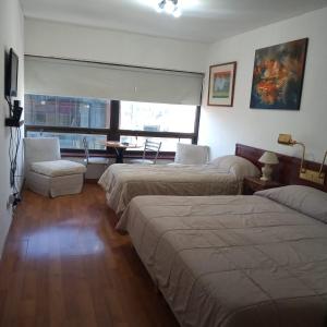 um quarto de hotel com duas camas e uma janela em CENTRO-OBELISCO BUENOS AIRES, conversión a dolar oficial venta em Buenos Aires