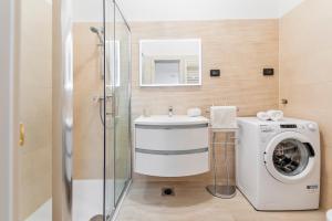 a bathroom with a washing machine and a sink at Comfort Apartments Karla in Rovinj