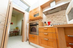 uma cozinha com armários de madeira e um forno com placa de fogão em Appartamento Napoli nel cuore di Bari em Bari