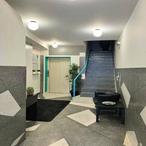 a lobby with a staircase with a chair and a stair case at bnapartments Trindade in Porto