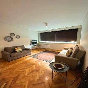 a living room with two couches and a large screen at bnapartments Trindade in Porto
