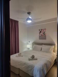sypialnia z dużym łóżkiem z dwoma ręcznikami w obiekcie Bovis Apartments #1 w mieście Markopoulo Mesogaias