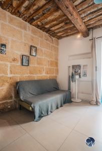een slaapkamer met een bed in een bakstenen muur bij Maison de village atypique à 5min du Pont du Gard in Vers Pont du Gard