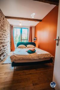 een slaapkamer met een bed met oranje muren en een raam bij Maison de village atypique à 5min du Pont du Gard in Vers Pont du Gard