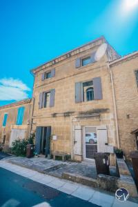 een groot bakstenen gebouw met deuren en ramen bij Maison de village atypique à 5min du Pont du Gard in Vers Pont du Gard