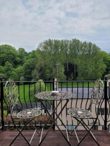 un patio con tavolo e sedie sul balcone. di Luxury Penthouse on Waterside Knaresborough a Knaresborough